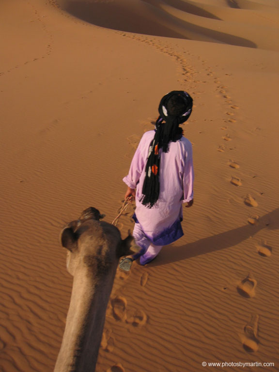 Man Leading Camel in the Desert